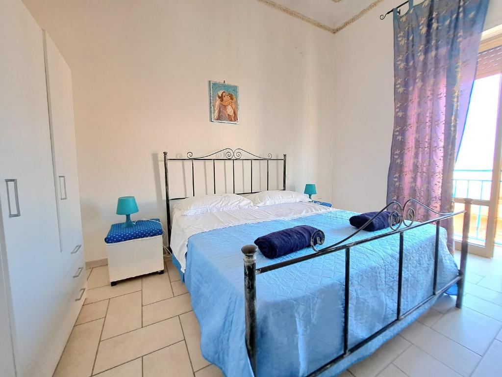 トラーパニにあるCoralli Di Mare Apartmentsのベッドルーム1室(青い掛け布団付きのベッド1台付)