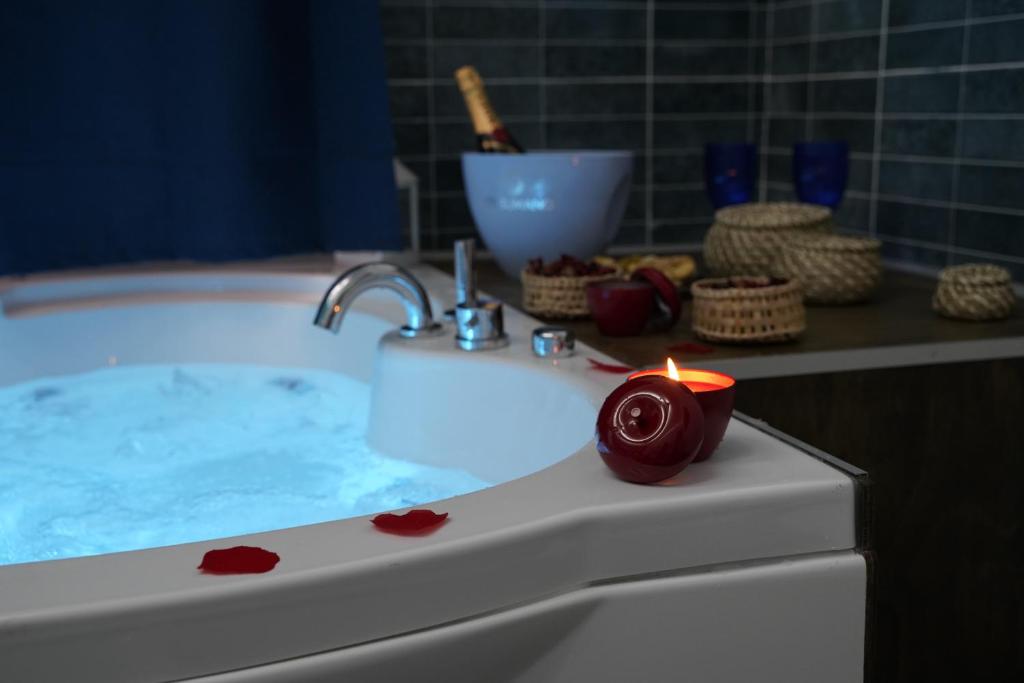 a candle sitting on a bathroom sink with a tub at Airport suite in Catania