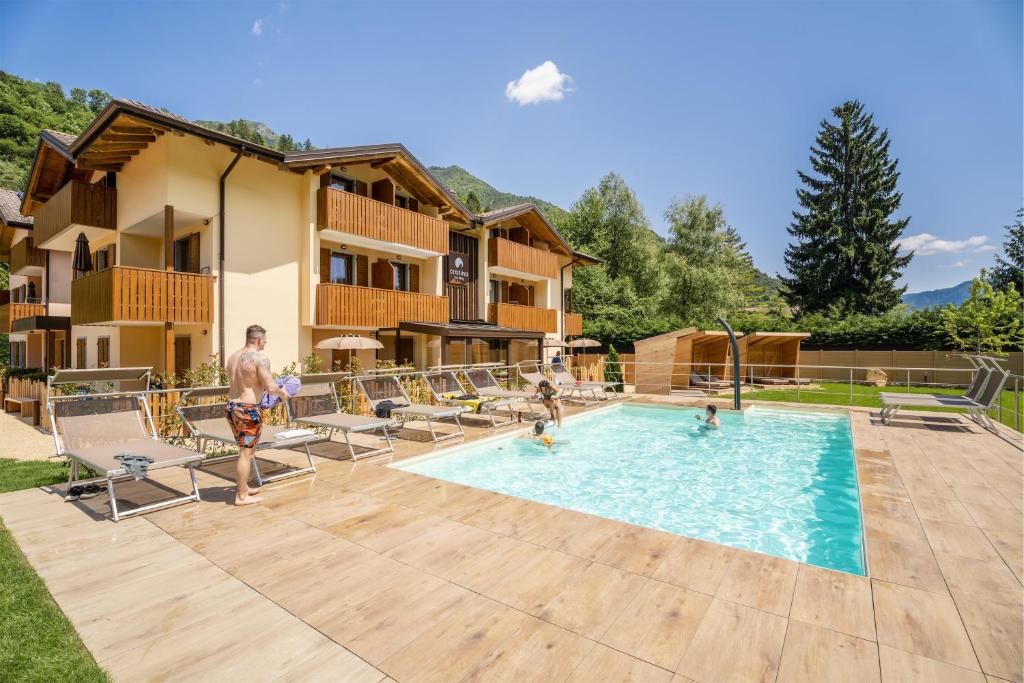 a man standing in front of a swimming pool at Residence Toli in Ledro