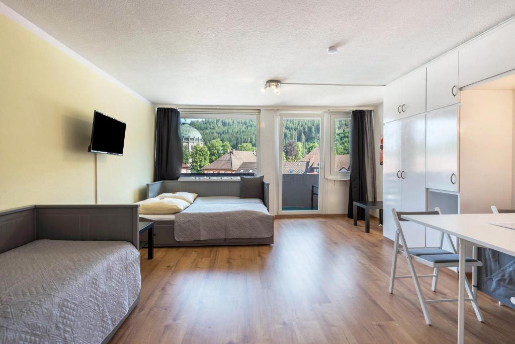 um quarto com uma cama e uma mesa com uma secretária em Kloster Meister Haus Apartment 12 em St. Blasien
