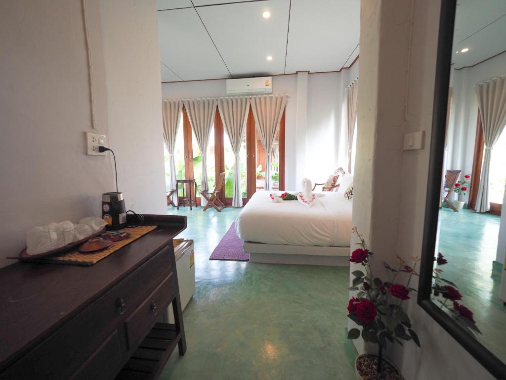 a bedroom with a bed and a dresser in a room at BaanSuk Sukhothai Resort in Sukhothai