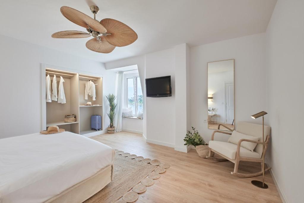 ein weißes Schlafzimmer mit einem Bett und einem Deckenventilator in der Unterkunft Hotel del Mar in Sanxenxo