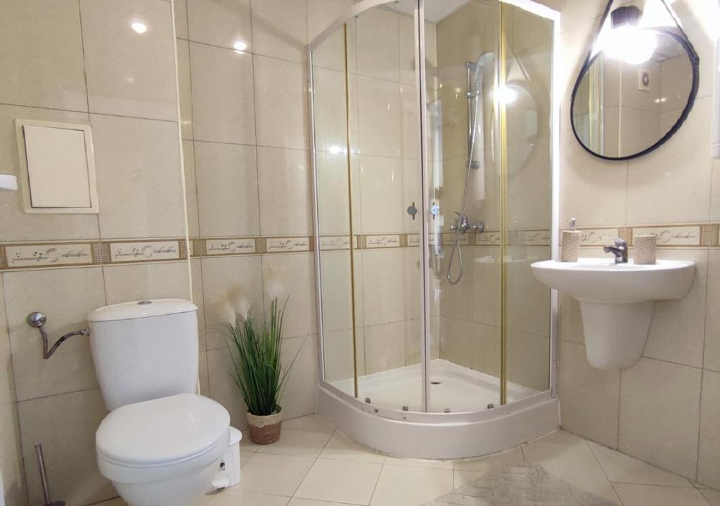 a bathroom with a shower and a toilet and a sink at Апартамент FLAME in Sunny Beach