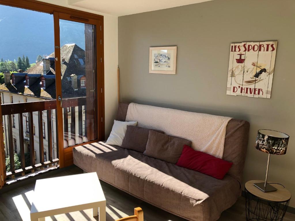 sala de estar con sofá y balcón en Le Perce Neige - plein centre en Luchon