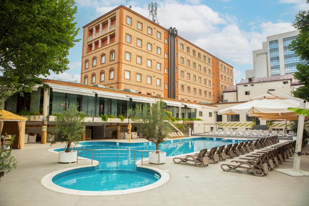 葉瑞文的住宿－Best Western Plus Congress Hotel Yerevan，一座带椅子的大型游泳池和一座建筑