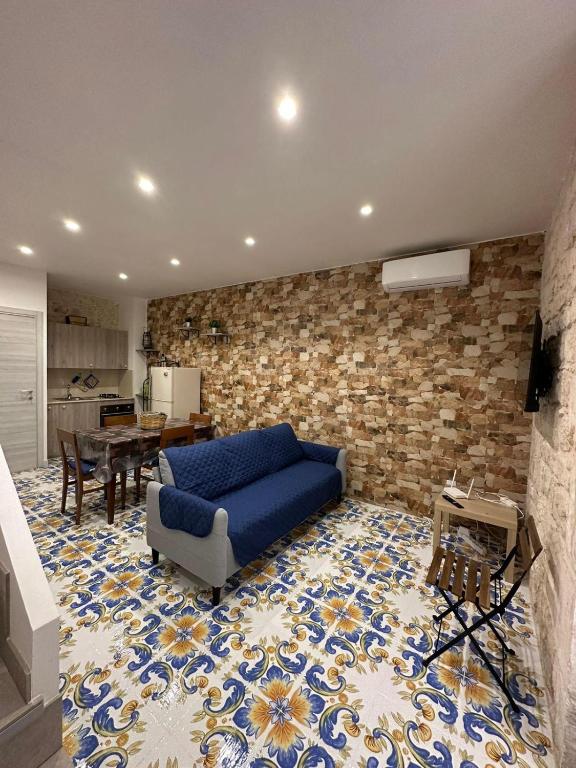a living room with a blue couch and a brick wall at IL RIFUGIO BAROCCO in Modica