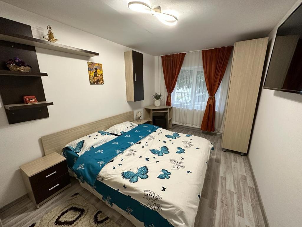 Un dormitorio con una cama con mariposas azules. en Mara en Făgăraş