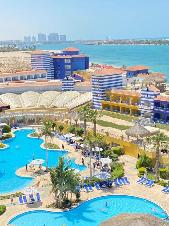 an aerial view of a resort with pools and umbrellas at شاليه في بورتو مارينا الساحل الشمالي العلمين 22 in El Alamein