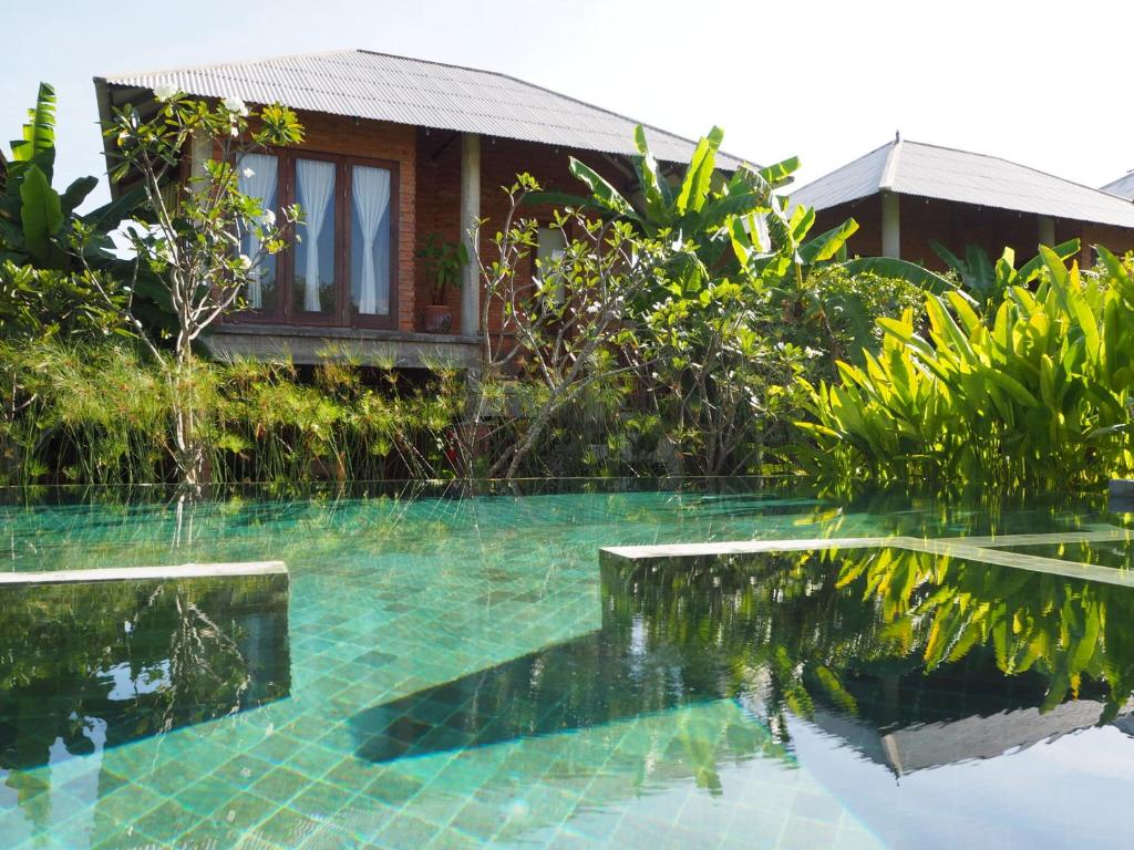 a swimming pool in front of a house at BaanSuk Sukhothai Resort in Sukhothai