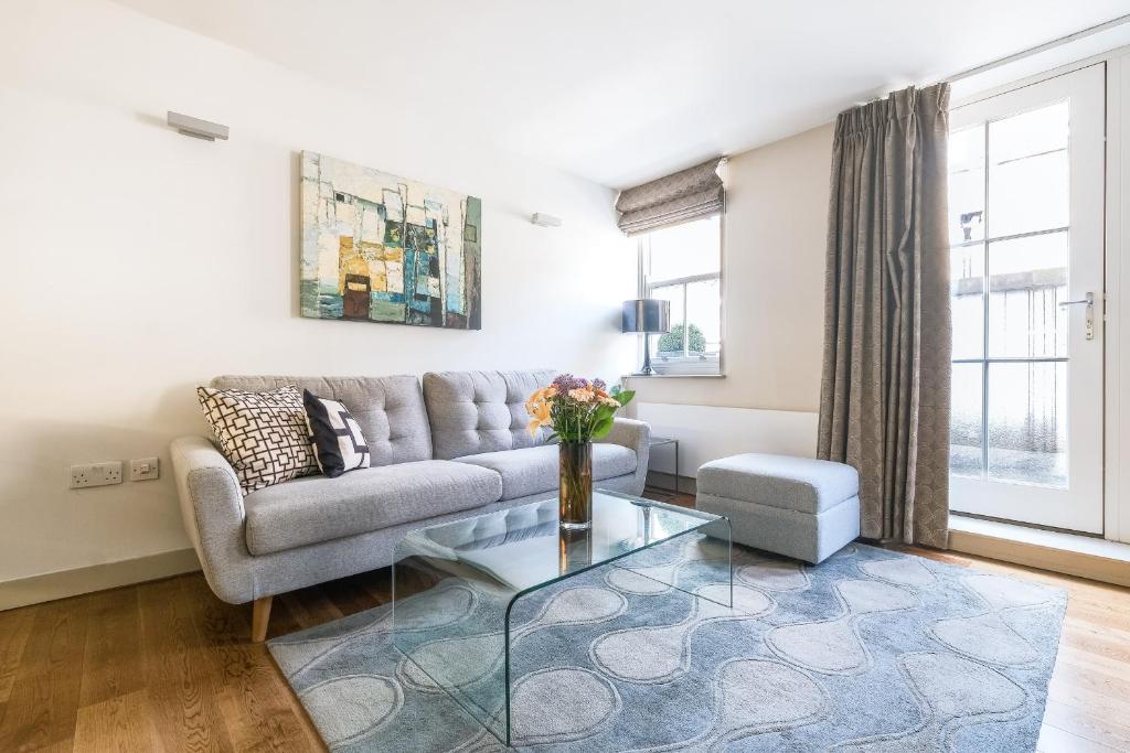 a living room with a couch and a glass table at Artillery Lane in London