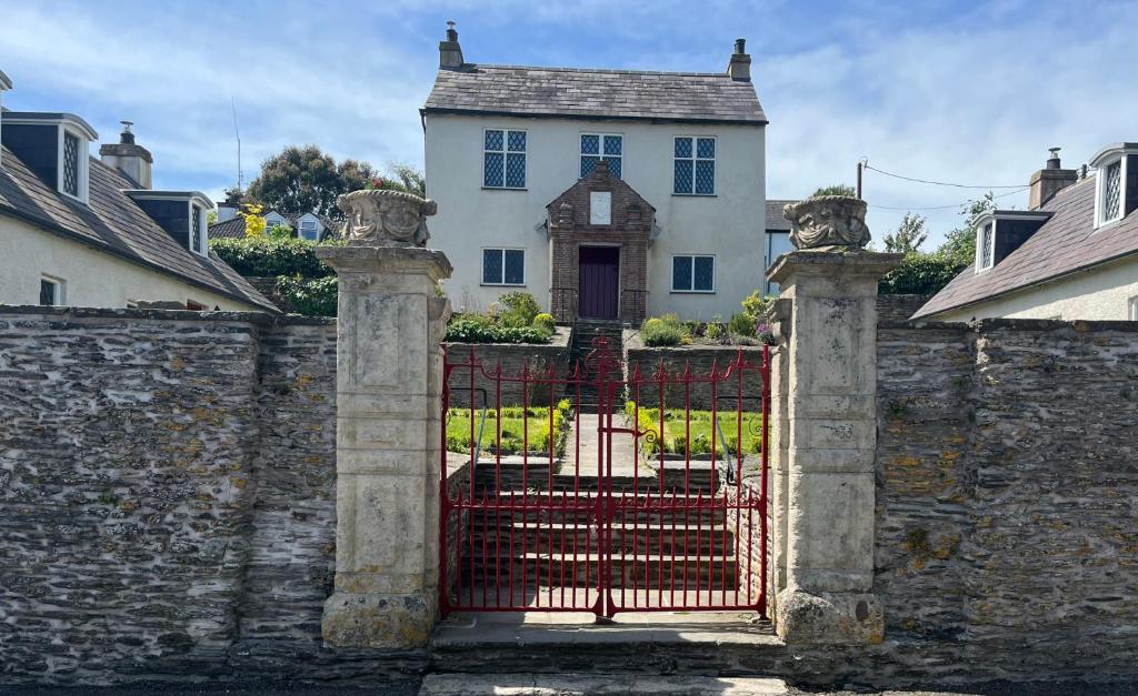 a gate in front of a white house at Alms Houses in Kinsale