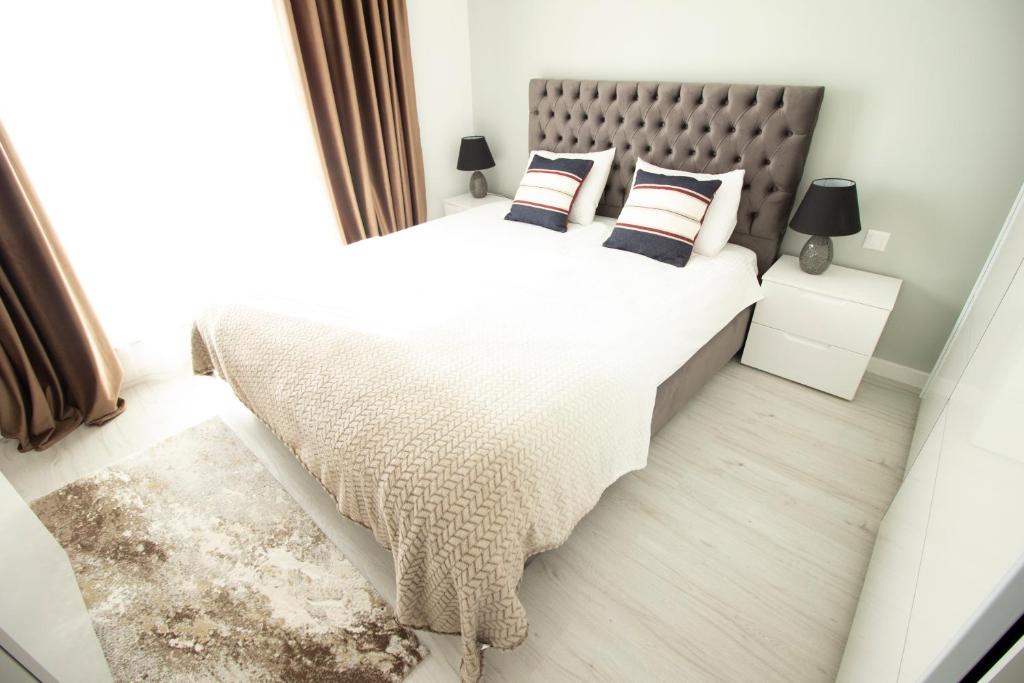 a bedroom with a large bed with two pillows at 2 Rooms A504 StayInn by Cosmopolis in Ştefăneştii de Jos