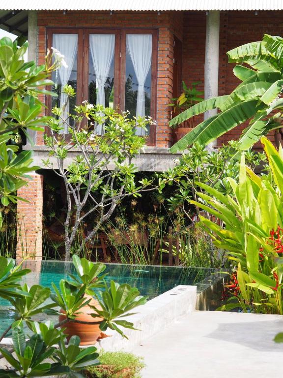 a house with a window and a swimming pool at BaanSuk Sukhothai Resort in Sukhothai