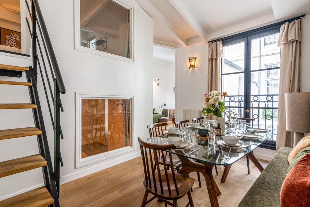 une salle à manger avec une table et des chaises et une cheminée dans l'établissement Appartement Pastourelle du Marais - Welkeys, à Paris