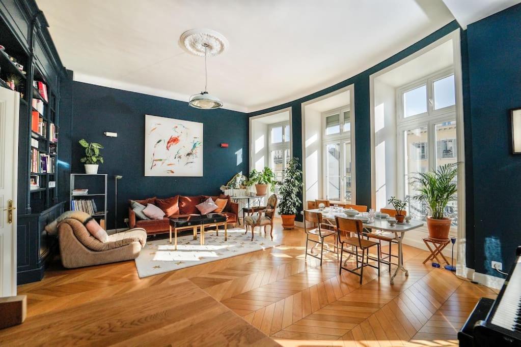 - un salon avec des murs bleus, une table et des chaises dans l'établissement S8 Grimaldi Suite Centrale 5min de la Mer AC, à Nice