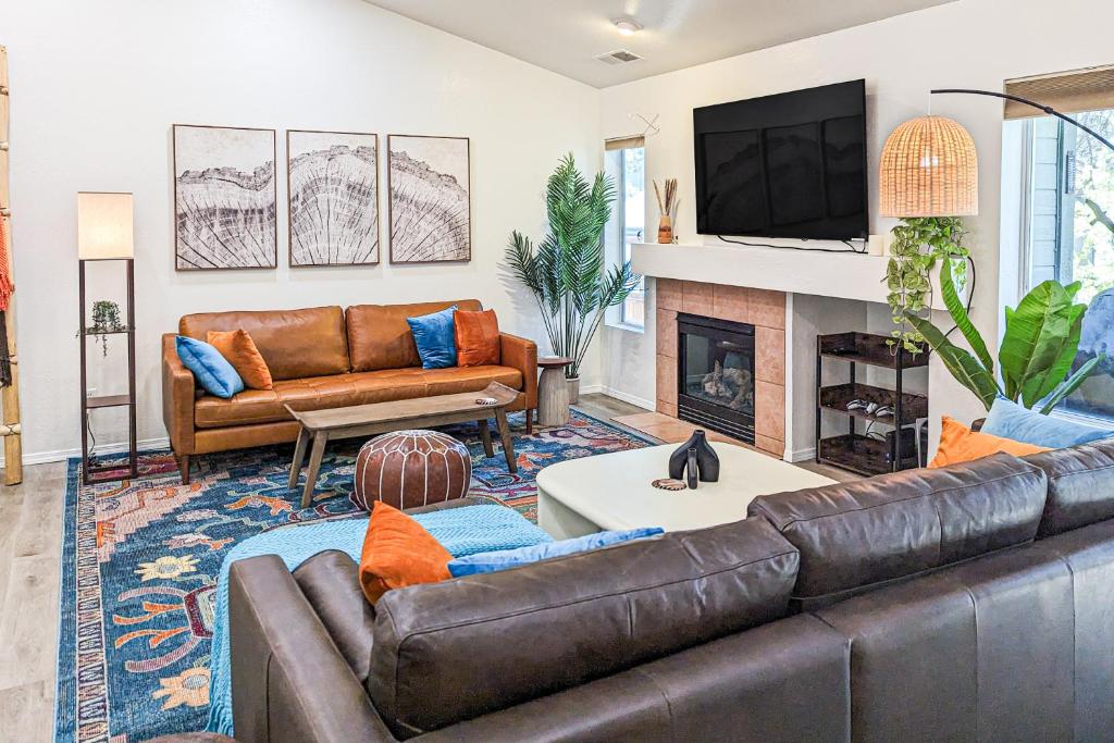 uma sala de estar com um sofá de couro e uma lareira em Adventurer's Haven em Flagstaff