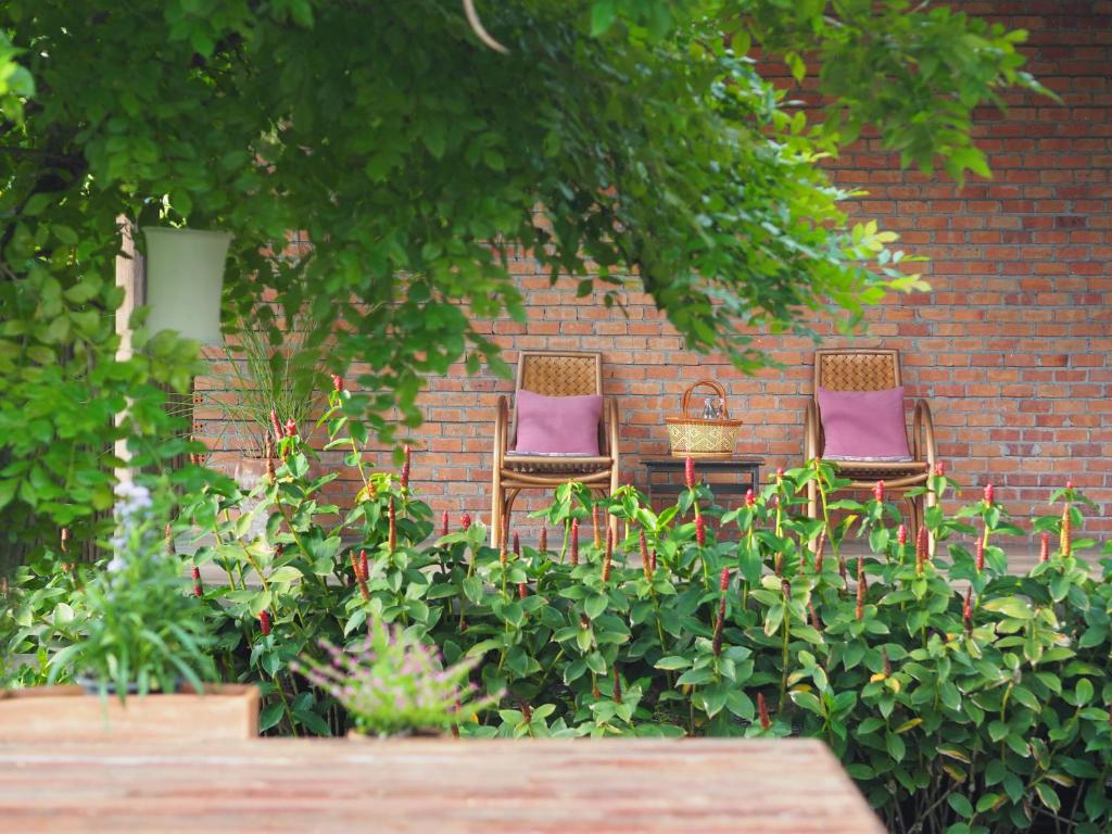 two chairs with purple cushions sitting against a brick wall at BaanSuk Sukhothai Resort in Sukhothai