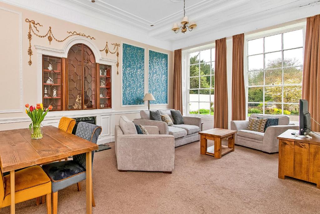 een woonkamer met een bank en een tafel bij Finest Retreats - Hambleton Hall Apt in Thirsk