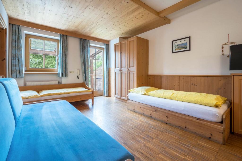um quarto com duas camas e um sofá em Lindenhof Apt 5 em Vandoies