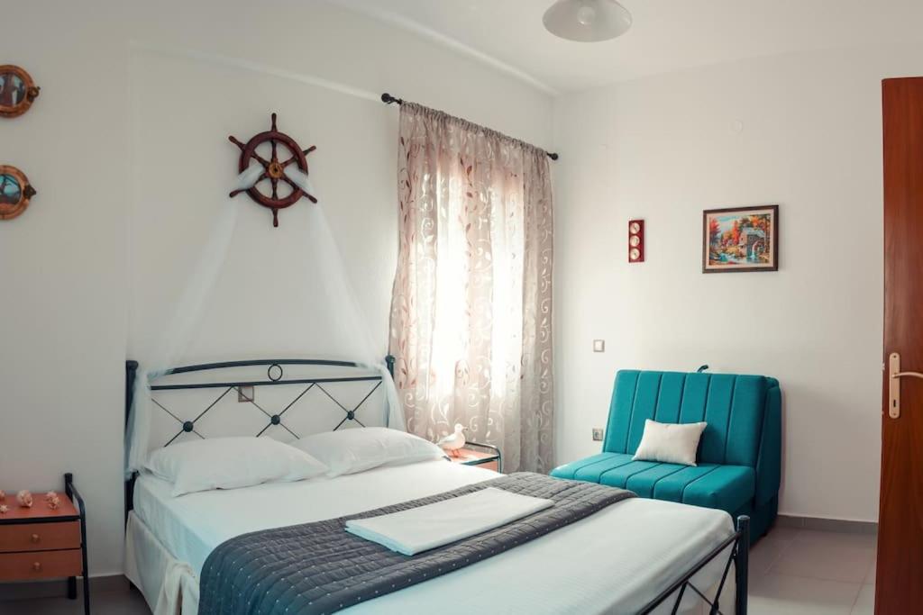 sypialnia z łóżkiem i niebieskim krzesłem w obiekcie Seagull House w mieście Ayía Kiriakí