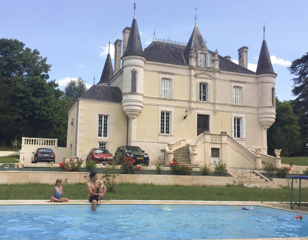 deux enfants dans une piscine devant un château dans l'établissement Chateau de la Brillere, à Verrières
