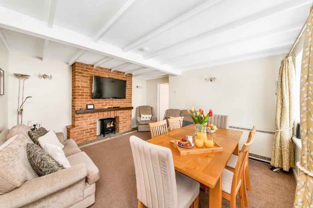 a living room with a table and a fireplace at Finest Retreats - Ryedale Hall Cottage in Thirsk