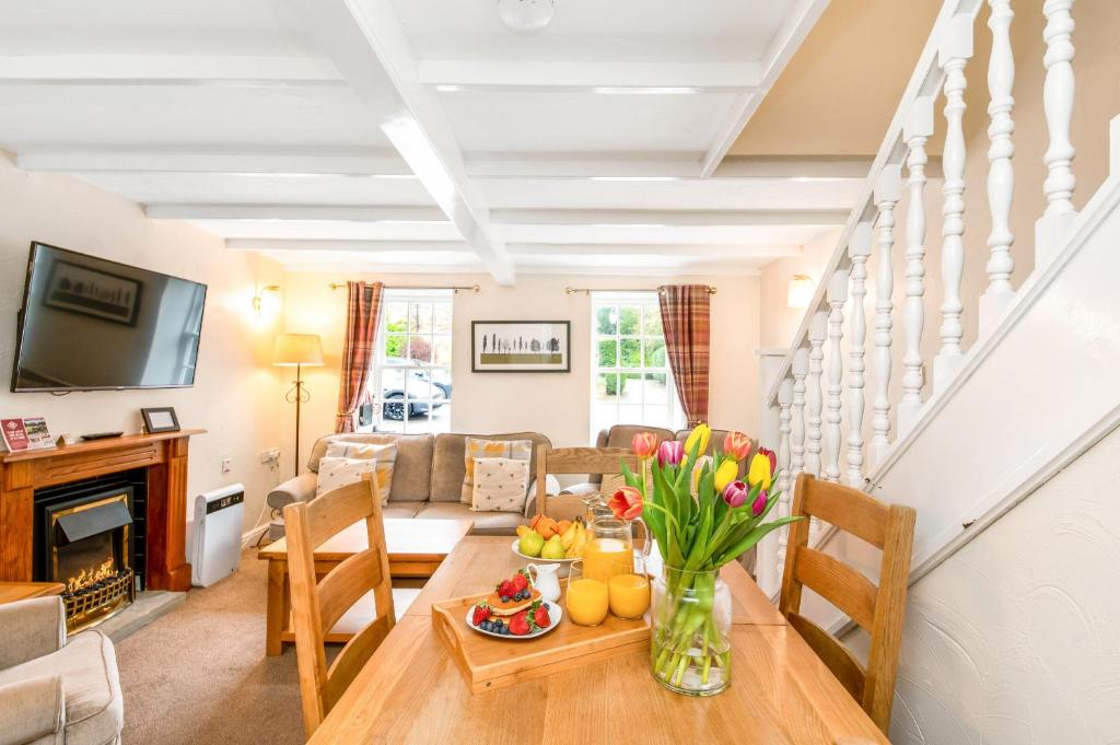 a living room with a table with a vase of flowers at Finest Retreats - Swaledale Hall Cottage in Thirsk
