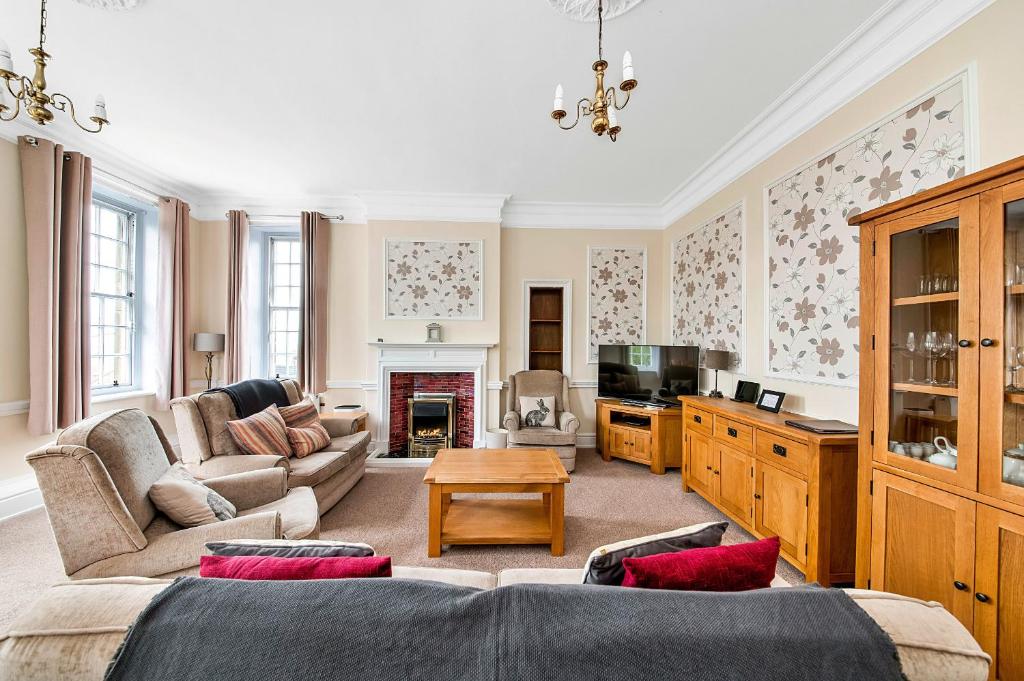 ein Wohnzimmer mit einem Sofa und einem TV in der Unterkunft Finest Retreats - York Hall Apt in Thirsk
