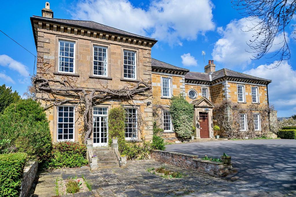 a large brick house with a driveway in front of it at Finest Retreats - Sutton Hall Apt in Thirsk