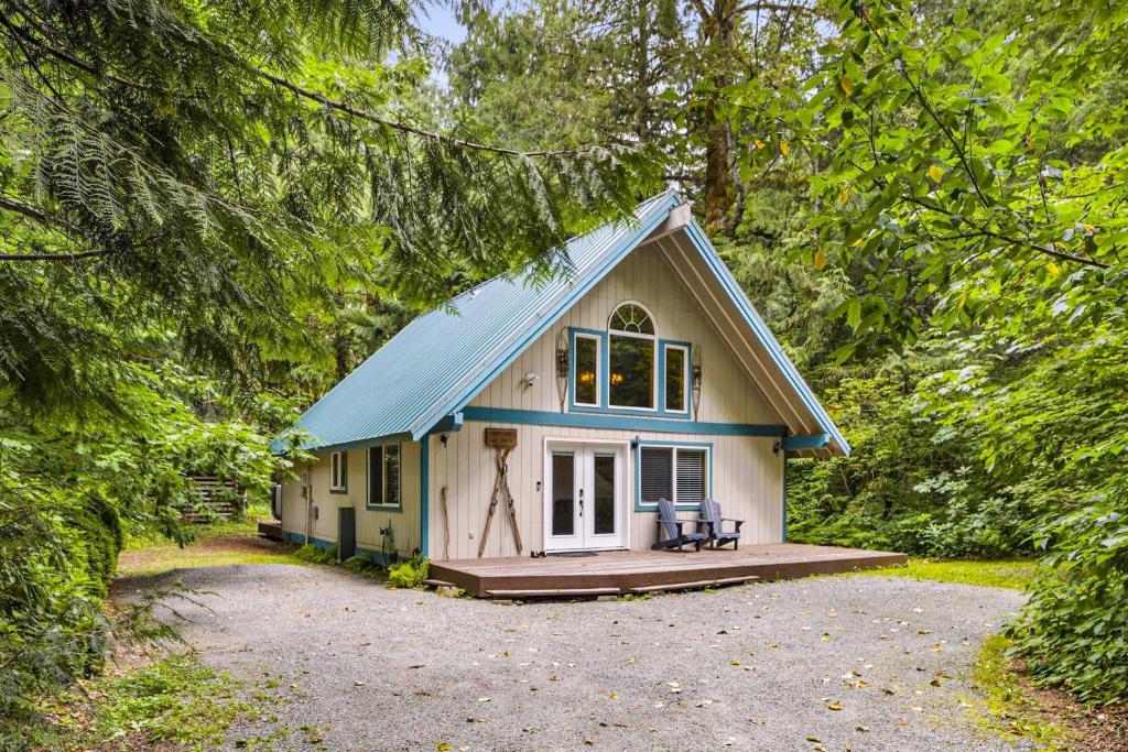 a small house with a blue roof in the woods at Sky One in Skykomish