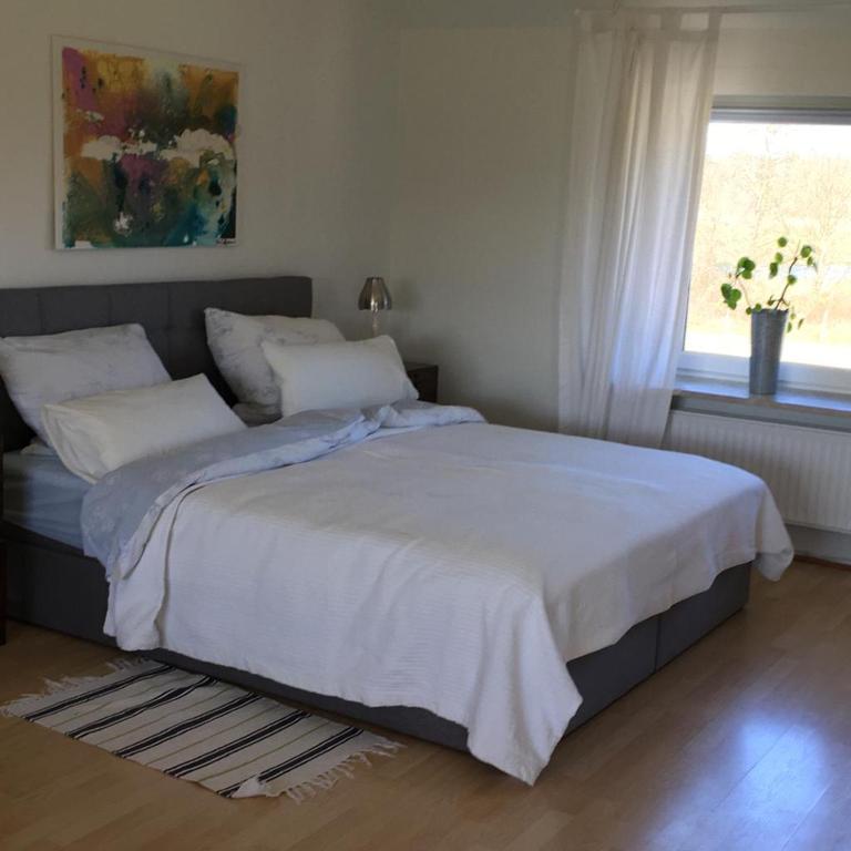 a bedroom with a bed with white sheets and a window at Ferienwohnung am Klosterforst 