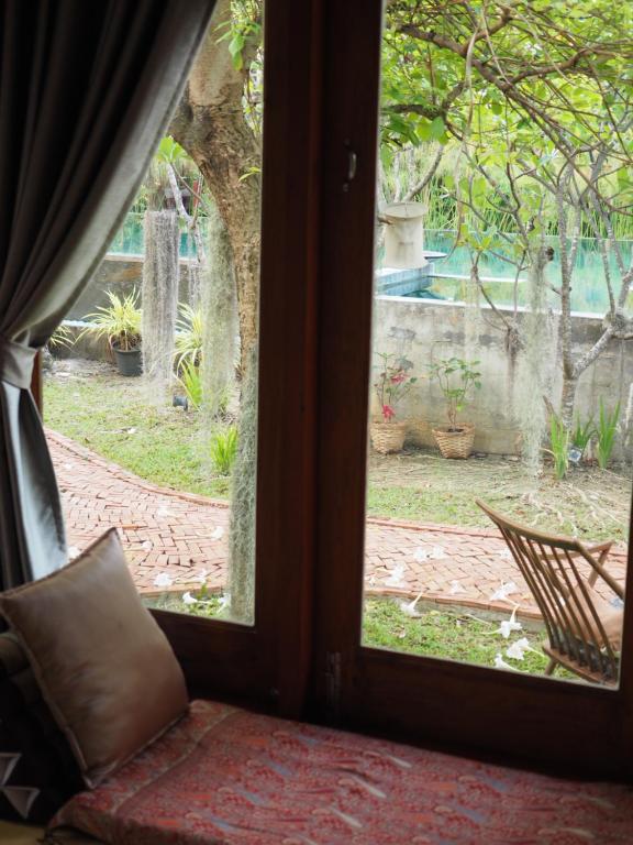 a view of a garden from a window at BaanSuk Sukhothai Resort in Sukhothai