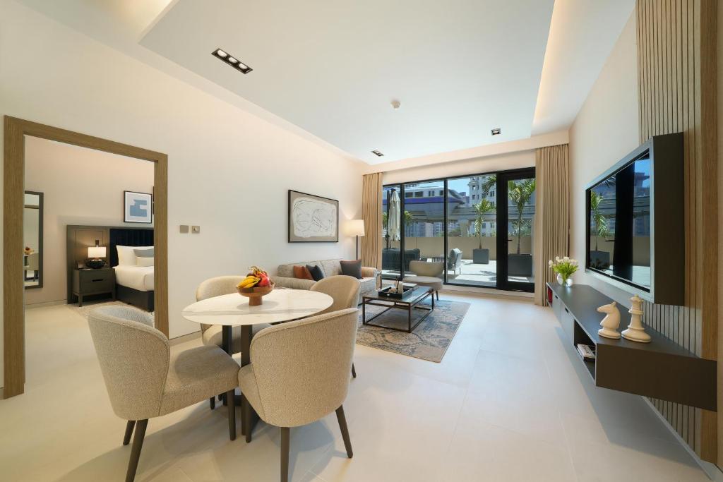 sala de estar con mesa y sillas en Cheval Maison - The Palm, en Dubái
