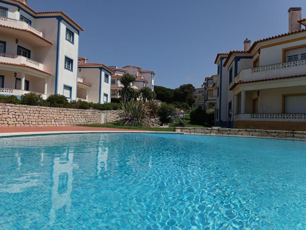 a large swimming pool in front of some buildings at Apartamento em D'el Rey-Obidos Beach & Surf in Amoreira
