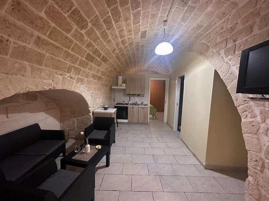 een woonkamer met een bank en een tv in een stenen muur bij futura home centro storico 5 minuti da Bari in Modugno