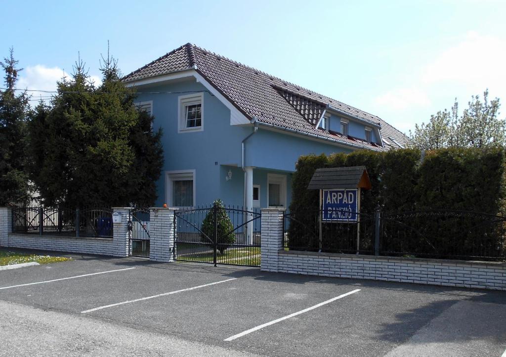 uma casa azul com um sinal numa cerca em Árpád Panzió em Gyor