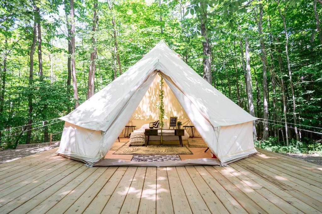 a tent on a deck in the woods at Grotto Getaway in Miller Lake