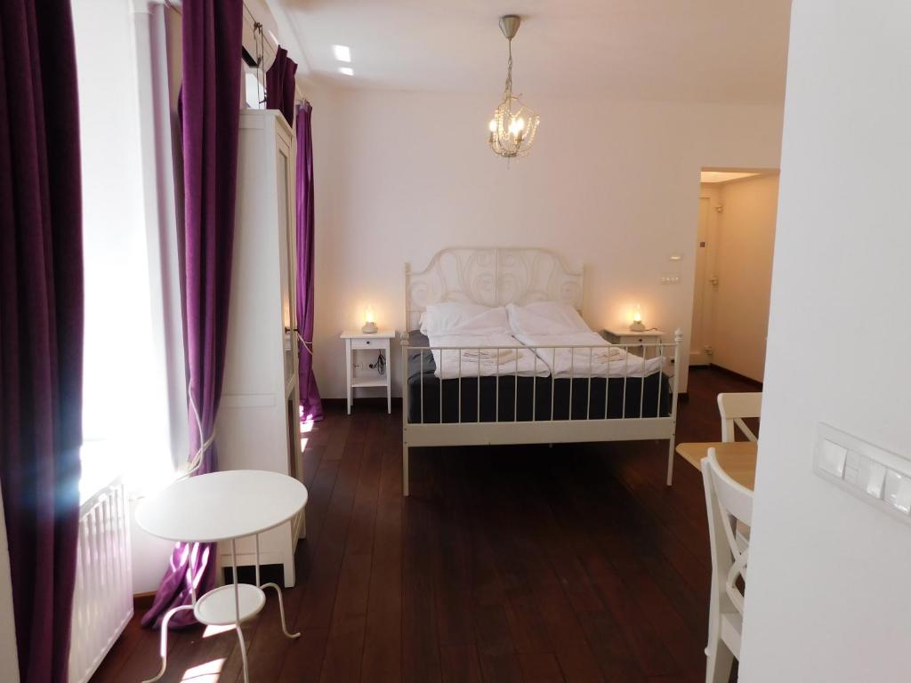 a bedroom with a white bed and a table at Apartment Keymaster's Hideaway in Ljubljana