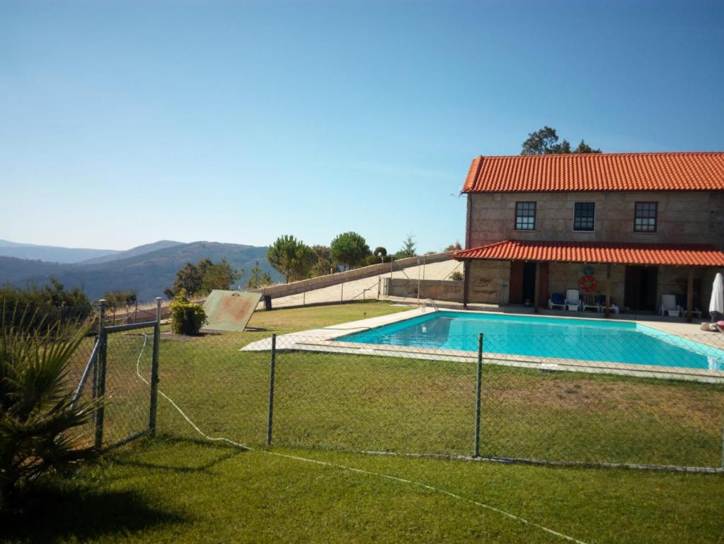 a swimming pool in front of a house at Quinta Do Quetrofe in Guarda
