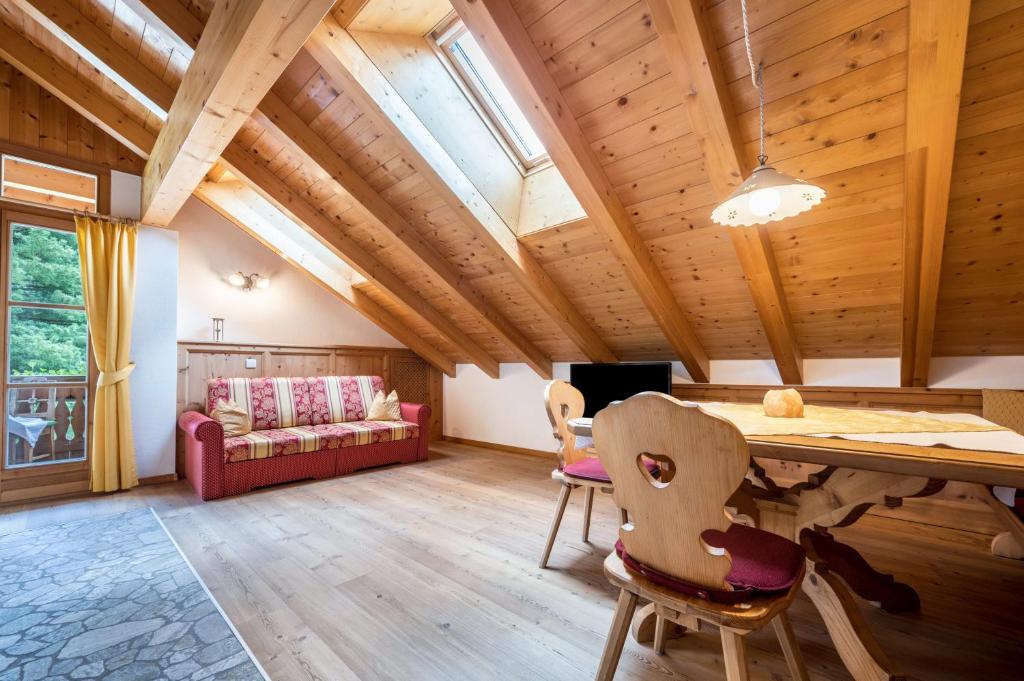 a living room with wooden ceilings and a table and chairs at Mitterbruggehof Apt Silberdistel in Anterselva di Mezzo