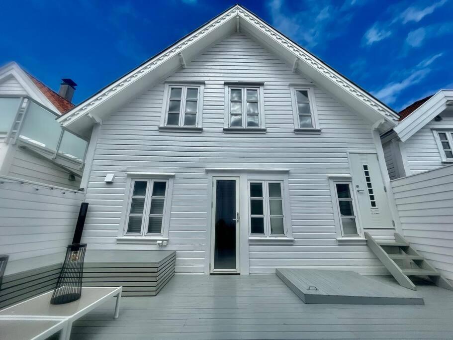 a white house with a front door and a porch at The Green Door H2 in Stavanger