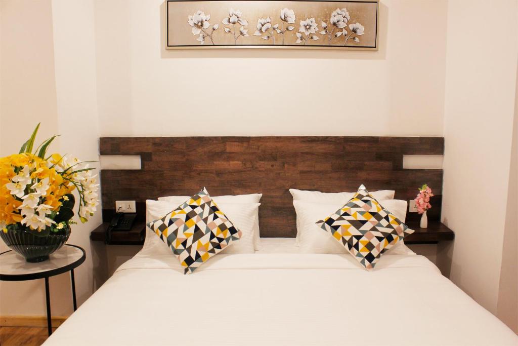 una camera con un letto bianco con due cuscini di Hotel Mayto a Thimphu
