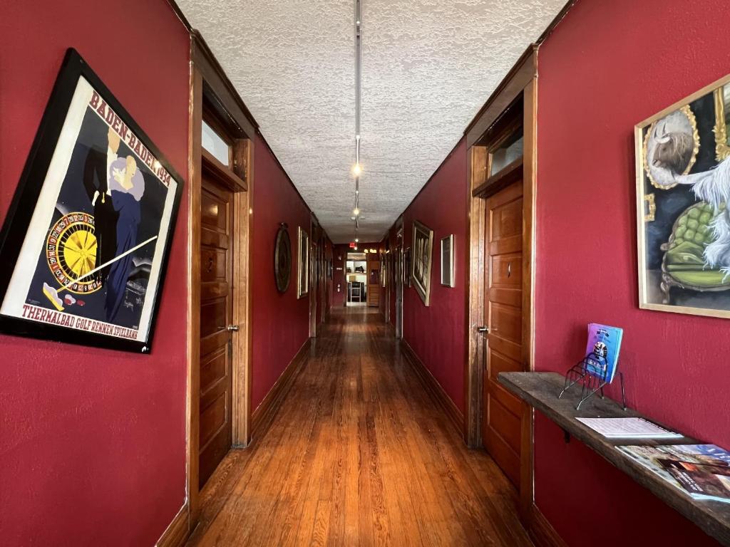 a long hallway with red walls and wooden floors at The Oliver House in Bisbee