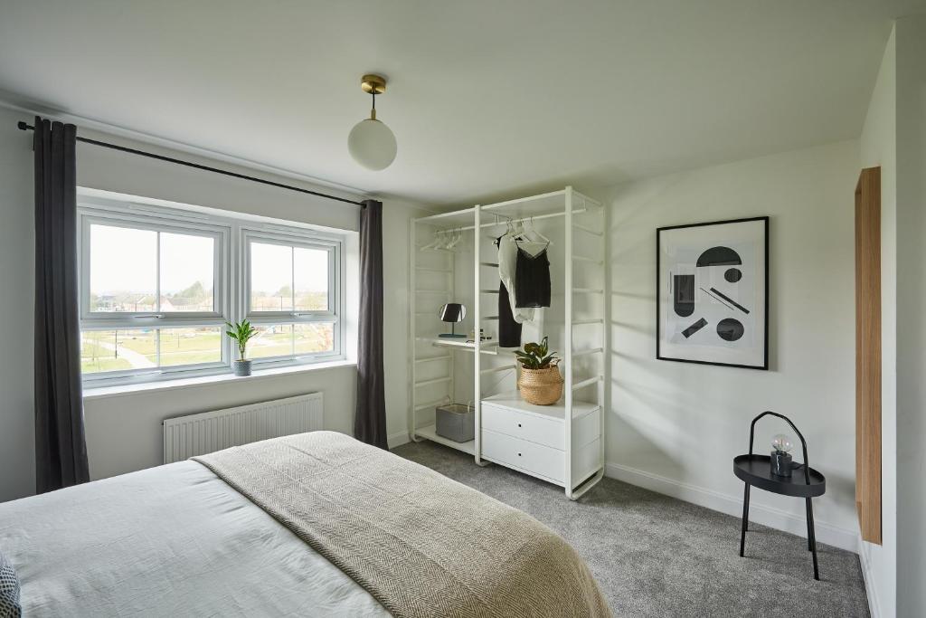 a white bedroom with a bed and a window at Coventry Home for 6+2, 150Mbp Wi-Fi + Parking in Canley