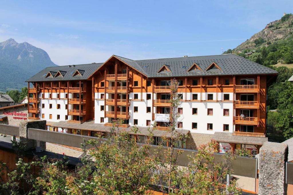 - une vue sur un hôtel avec des montagnes en arrière-plan dans l'établissement Résidence Néméa L'Aigle Bleu, à Briançon