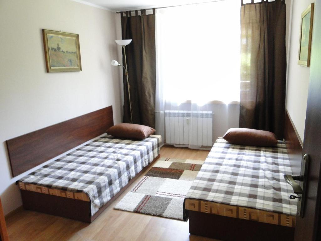een slaapkamer met 2 bedden en een raam bij Apartament Kasprusie 65m2 in Zakopane