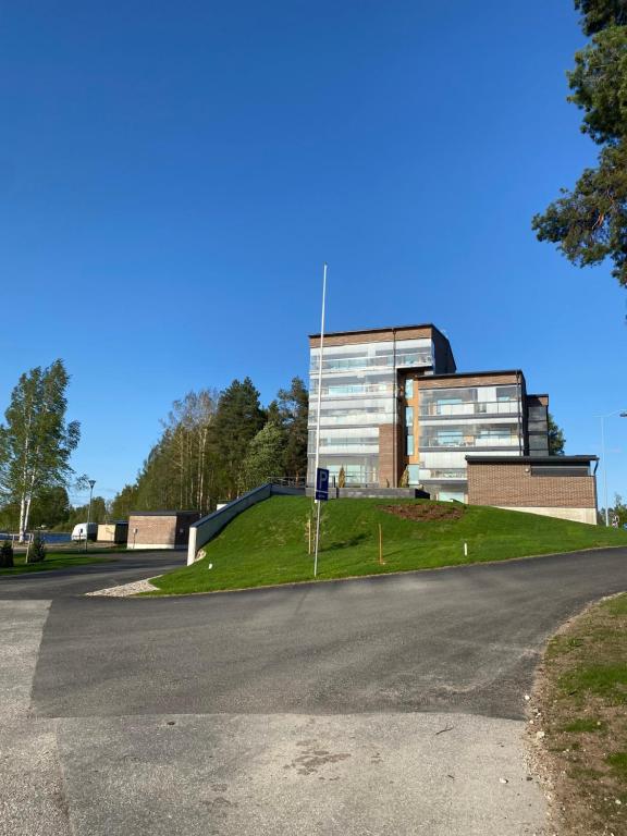 a building on a hill next to a road at Tyylikäs saunallinen huoneisto Sotkamon satamassa in Sotkamo