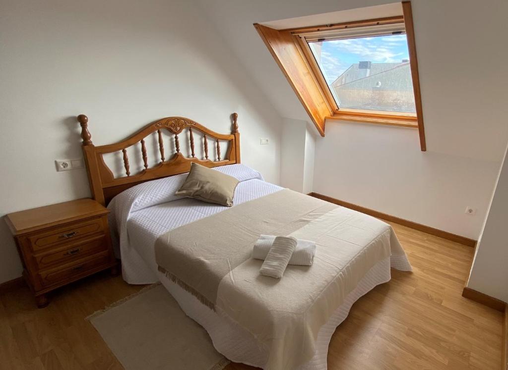 a bedroom with a white bed with a window at A CUARTA RONDA in Melide