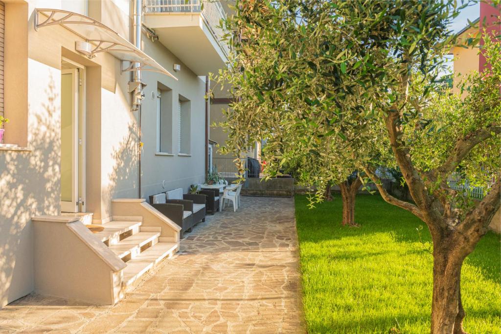 a house with a courtyard with a tree at Casa Vacanze Cattolica in Cattolica