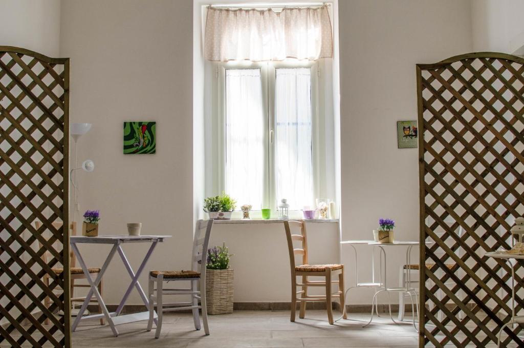 ナポリにあるBed & Breakfast Lady-Bのテーブルと椅子、窓が備わる客室です。